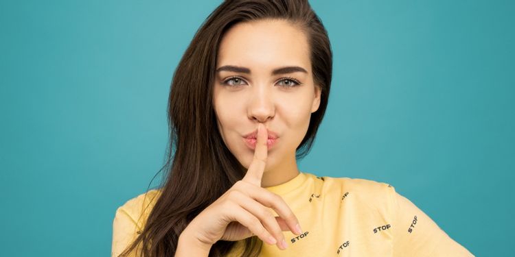 woman holding finger to lips